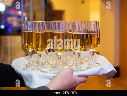 white wine glasses served on a tray with a white cloth at a party Stock Photo