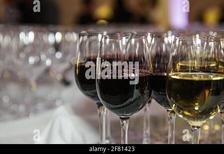 glasses of wine sitting on a table ready to be picked up choice of red or white Stock Photo