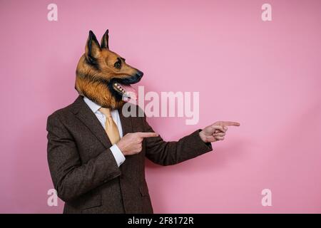 Young man in a latex dog head mask holding a weight scale on a pink  background Stock Photo - Alamy