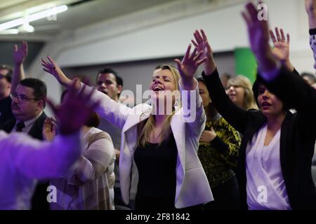 Practitioners of the Evangelical faith raise their hands during evangelical event at Evangelical Community South Zone in London , UK Stock Photo