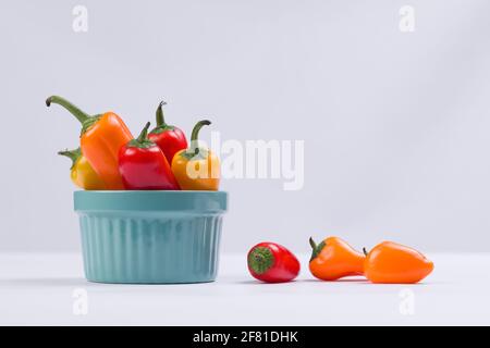 A studio photo of sweet peppers in a blue bowl against a white background. Stock Photo