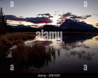 Calm lake in the morning with light on top of the mountains in summer Stock Photo