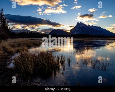 Calm lake in the morning with light behind the mountains in summer Stock Photo