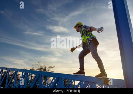 Engineer technician worker working in a metal roof structure of warehouse, Construction worker wear safety uniform at height equipment inspection meta Stock Photo