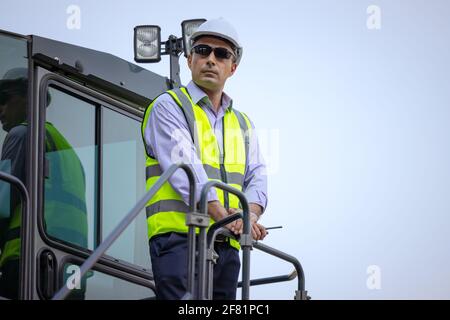 Construction man driver with excavator outdoor site, Industrial Manager Stock Photo