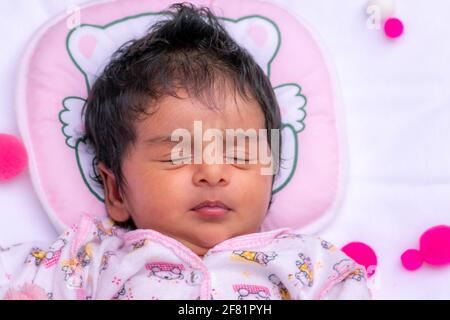 Cute newborn baby girls one-month birthday celebration photo session, Napping and dreaming time for the adorable infant. close up overhead view photog Stock Photo