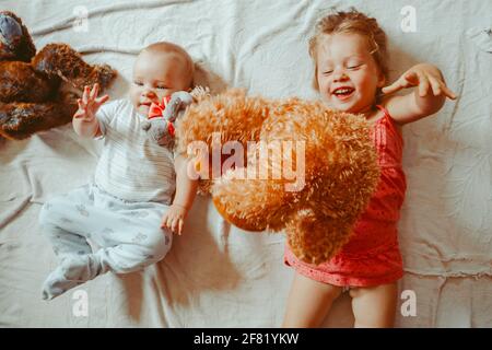 children lie on the floor next to each other, brother and sister play Stock Photo