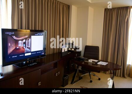 DUBAI, UNITED ARAB EMIRATES - JUN 16, 2019: A work desk in a luxurious business hotel room with a TV Stock Photo