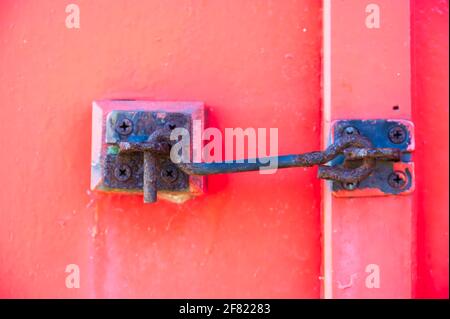 Door security latch metal hook on red door Stock Photo - Alamy