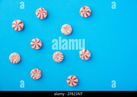 Round candy caramel red and white on a blue background Stock Photo