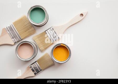 Overhead view of a DIY paint brush with colorful sample paint pots Stock Photo