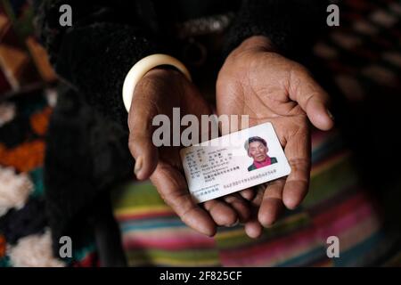 (210411) -- XIGAZE, April 11, 2021 (Xinhua) -- Lahpa holds her ID card at her home in Puga Village of Xigaze, southwest China's Tibet Autonomous Region, March 20, 2021. Lhapa, born in 1945, is a villager in Puga Village. When she was a child, her mother became blind due to overwork and lost the ability to work. The serf owner drove her out of the manor, and Lhapa's mother had to beg everywhere with her sister for a living. In 1959, during the democratic reform in Tibet, the Lhapa's family were finally reunited and alloted 24 mu (about 1.6 hectare) of land, six sheep and two cows. They also Stock Photo