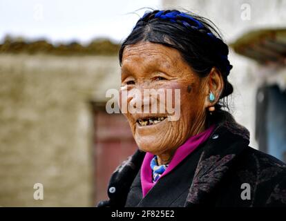 (210411) -- XIGAZE, April 11, 2021 (Xinhua) -- Lhapa poses for a photo in Puga Village of Xigaze, southwest China's Tibet Autonomous Region, March 20, 2021. Lhapa, born in 1945, is a villager in Puga Village. When she was a child, her mother became blind due to overwork and lost the ability to work. The serf owner drove her out of the manor, and Lhapa's mother had to beg everywhere with her sister for a living. In 1959, during the democratic reform in Tibet, the Lhapa's family were finally reunited and alloted 24 mu (about 1.6 hectare) of land, six sheep and two cows. They also built a hous Stock Photo