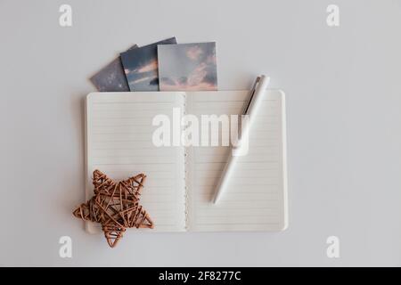 Blank opened notebook in line with pen and brown decor star on white background. Decorated with pictures clouds, space. Top view of open empty noteboo Stock Photo