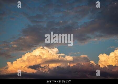 Dramatic sky before storm. Cumulonimbus during sunset. Top of cumulus clouds Stock Photo