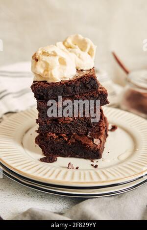 A vertical shot of a delicious brownie with ice cream on a white plate ...