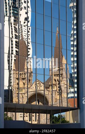 Saint John's Cathedral in Brisbane reflects in the office building across the road representing the old and new Stock Photo