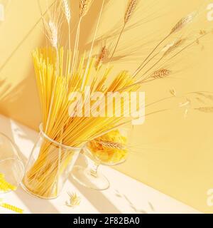 Sunny food composition of raw spaghetti, farfalle and girandole pasta in a glasses on white table. Zero waste concept, no plastic. Sale and storage of Stock Photo