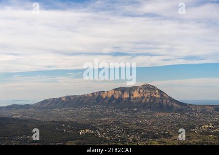 Mountain between villages on a clear day with few clouds, the sea in the background. In Alicante, Spain. Montgo Massif Natural Park Stock Photo
