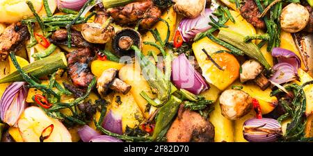 Baked meat with potatoes,apples,mushrooms and okra.Roasted meat with vegetables. Stock Photo