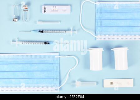 Rapid antigen test, medical face masks, vaccine vials with syringe and medication bottles. Tools to fight Corona Virus pandemic Stock Photo