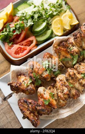 British chicken wings that have been marinaded in Ras el Hanout Moroccan spices before being skewered and grilled at home. Served with a coriander, on Stock Photo
