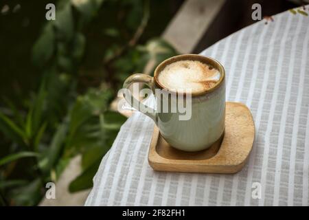 Cup of coffee latte with heart shape on old wooden background in the morning sunlight Stock Photo