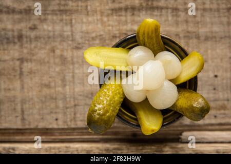 A bowl of pickled gherkins and onions. England UK GB Stock Photo