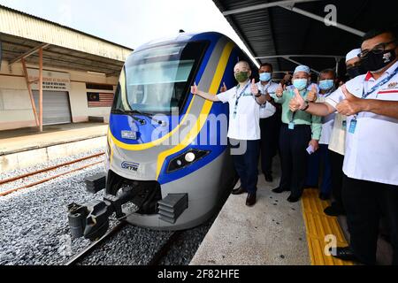 Kota Bharu, Malaysia's northern Kelantan state. 11th Apr, 2021. Malaysian Transport Minister Wee Ka Siong (L) poses for photos with the Diesel Multiple Unit train in Kota Bharu, the capital of Malaysia's northern Kelantan state, April 11, 2021. The Diesel Multiple Unit (DMU) trains manufactured by China Railway Rolling Stock Corporation (CRRC) Zhuzhou Electric Locomotive Co., Ltd were launched into operations on Sunday, which will boost connectivity and facilitate travel in Malaysia's eastern coast area. Credit: Zhu Wei/Xinhua/Alamy Live News Stock Photo