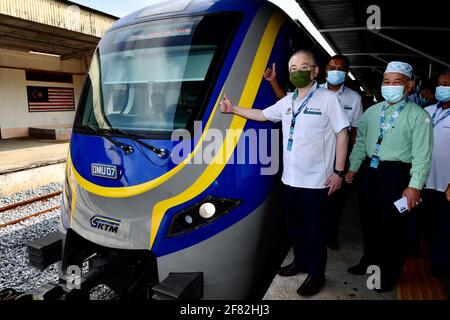 Kota Bharu, Malaysia's northern Kelantan state. 11th Apr, 2021. Malaysian Transport Minister Wee Ka Siong (L) poses for photos with the Diesel Multiple Unit train in Kota Bharu, the capital of Malaysia's northern Kelantan state, April 11, 2021. The Diesel Multiple Unit (DMU) trains manufactured by China Railway Rolling Stock Corporation (CRRC) Zhuzhou Electric Locomotive Co., Ltd were launched into operations on Sunday, which will boost connectivity and facilitate travel in Malaysia's eastern coast area. Credit: Zhu Wei/Xinhua/Alamy Live News Stock Photo