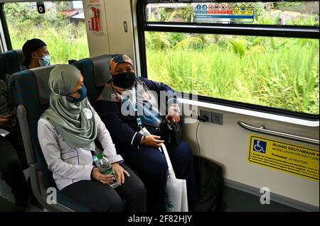 Kota Bharu, Malaysia's northern Kelantan state. 11th Apr, 2021. People take a ride on the Diesel Multiple Unit train in Kota Bharu, the capital of Malaysia's northern Kelantan state, April 11, 2021. The Diesel Multiple Unit (DMU) trains manufactured by China Railway Rolling Stock Corporation (CRRC) Zhuzhou Electric Locomotive Co., Ltd were launched into operations on Sunday, which will boost connectivity and facilitate travel in Malaysia's eastern coast area. Credit: Zhu Wei/Xinhua/Alamy Live News Stock Photo