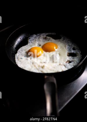 beautiful fried eggs in pan, shallow DOF in natural light closeup image Stock Photo