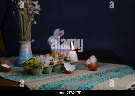 Easter decor in an egg box with dried flowers and candles with a hare Stock Photo