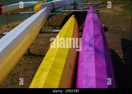 on the banks of the river lie a multi-colored canoe close-up Stock Photo
