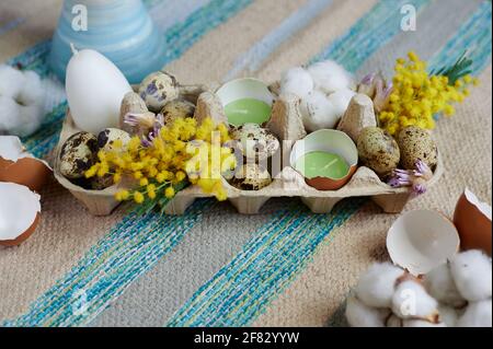 Easter decoration in an egg box with candles eggs and dried flowers Stock Photo
