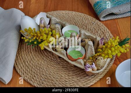Easter decor, mimosa, egg candles, eggshells, dried flowers Stock Photo