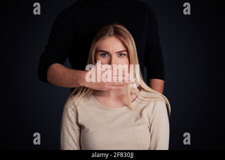 Tyranny, psychological pressure and discrimination concept. Male closes mouth of female Stock Photo