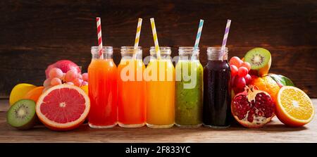 https://l450v.alamy.com/450v/2f833yc/bottles-of-fruit-juice-with-fresh-fruits-on-a-wooden-table-2f833yc.jpg