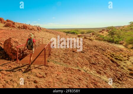 Backpacker after hiking crosses bridge of Walpa Gorge in Uluru-Kata Tjuta National Park. Kata Tjuta and her domes is a culturally sensitive area Stock Photo