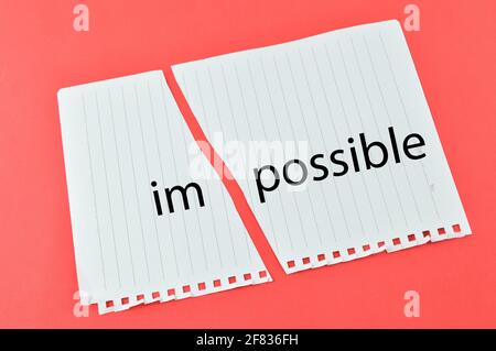Torn paper written with text IMPOSSIBLE over red background. Stock Photo