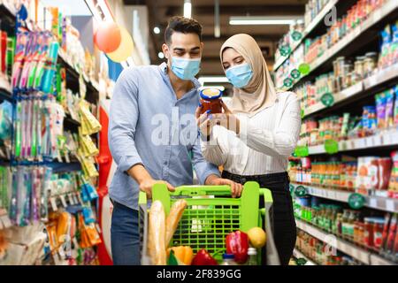 Muslim Family Doing Grocery Shopping Buying Food In Supermarket Stock Photo