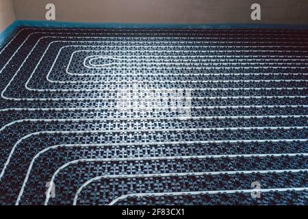 Pipes for underfloor heating ready to be covered with grout Stock Photo