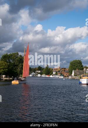 Sailing on The River Bure, part of The Norfolk Broad, at Picturesque Horning, with it Riverside Buildings, Horning, Norfolk, England, UK Stock Photo