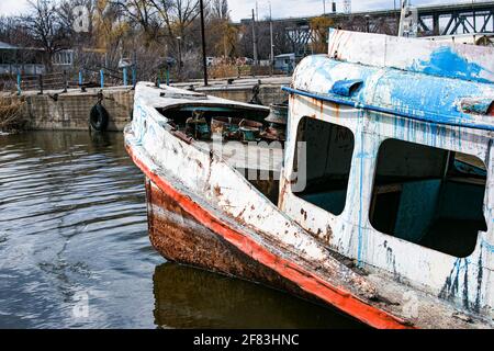 Old rusty sunken ship in the water on the territory of the river port. Old sunken boat on the river. Stock Photo