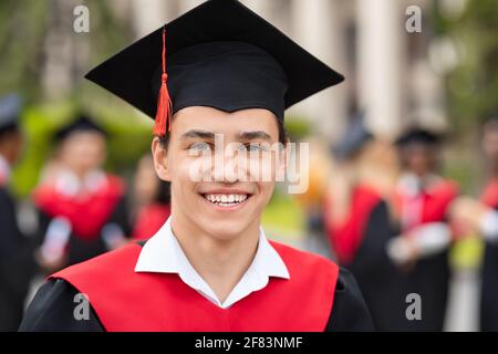 Closeup portrait of happy guy student wearing graduating costume Stock Photo