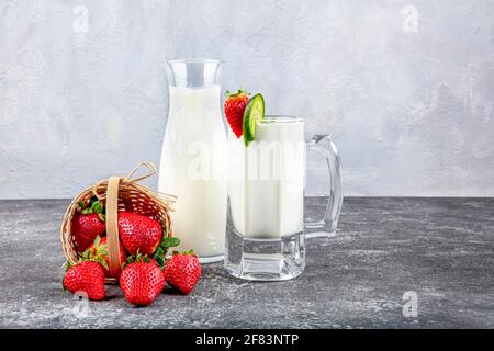 Healthy Organic Drinkable Yogurt Kefir in a Glass. Close-up shot on a full glass of white Kefir enriched with some mint leaves. Stock Photo