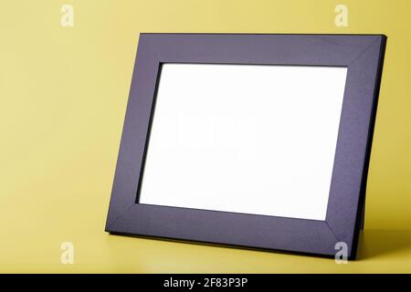 Black photo frame with free space on a yellow background. Place for the text Stock Photo