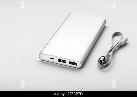 Powerbank for charging mobile devices with cable, on a white background. Universal external battery for gadgets. Isolate Stock Photo