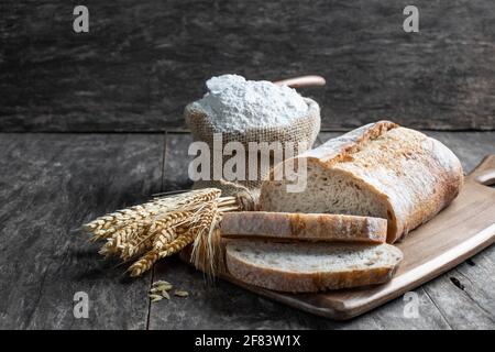 Fresh  homemade bread and flour in small burlap bag Stock Photo