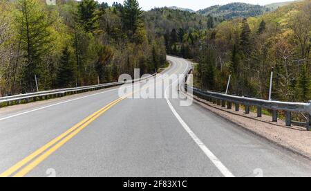 small one lane. road in summer in the countryside with a curve at the end Stock Photo